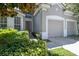 Inviting home exterior featuring a two-car garage, complemented by lush landscaping and a warm entryway at 2631 Archfeld Blvd, Kissimmee, FL 34747