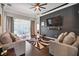 Spacious living room featuring dark floors, a ceiling fan, and access to the backyard at 2631 Archfeld Blvd, Kissimmee, FL 34747