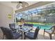 Enjoy outdoor dining poolside on the covered patio with seating for eight under a ceiling fan at 2631 Archfeld Blvd, Kissimmee, FL 34747