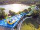 Aerial view of a community water park featuring slides, splash zones, and scenic lake views at 2631 Archfeld Blvd, Kissimmee, FL 34747