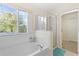 Bright bathroom featuring a large tub, tiled floors, and a clear glass shower stall at 277 Sand Ridge Dr, Davenport, FL 33896