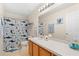 Bright bathroom with tiled floors, a shower-tub combo, and a long vanity with a large mirror and ample lighting at 277 Sand Ridge Dr, Davenport, FL 33896