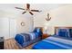 Cozy bedroom with wood floors, two beds with blue bedding, closet and nautical themed decor at 277 Sand Ridge Dr, Davenport, FL 33896
