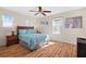 Cozy bedroom with hardwood floors, a ceiling fan, and natural light at 277 Sand Ridge Dr, Davenport, FL 33896