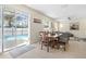 Dining room with a wooden table and chairs, adjacent to the screened-in pool area and living room at 277 Sand Ridge Dr, Davenport, FL 33896
