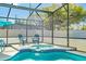This screened in patio features a relaxing hot tub with chairs nearby at 277 Sand Ridge Dr, Davenport, FL 33896
