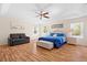 Large bedroom with hardwood floors, a ceiling fan, and large windows overlooking the lush greenery outside at 277 Sand Ridge Dr, Davenport, FL 33896
