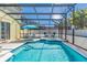 Relaxing screened-in pool and hot tub with lounge chairs and an umbrella-covered table set at 277 Sand Ridge Dr, Davenport, FL 33896