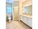 Bright bathroom with tile floors, a double vanity with marble countertop, toilet, and a glass-enclosed shower at 2956 Lucayan Harbour Cir # 108, Kissimmee, FL 34746