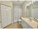Well-lit bathroom with tile floors, vanity with marble countertop, toilet, and shower with a decorative curtain at 2956 Lucayan Harbour Cir # 108, Kissimmee, FL 34746