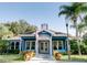 Charming blue clubhouse featuring well-kept landscaping, American flag, and outdoor seating at 2956 Lucayan Harbour Cir # 108, Kissimmee, FL 34746