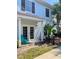 Charming exterior featuring a covered porch with a teal chair, complemented by lush tropical landscaping at 2956 Lucayan Harbour Cir # 108, Kissimmee, FL 34746
