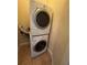 A stacked washer and dryer in a laundry room featuring tile floors at 2956 Lucayan Harbour Cir # 108, Kissimmee, FL 34746