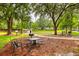 Community park area with picnic tables, a grill, and shady trees at 2956 Lucayan Harbour Cir # 108, Kissimmee, FL 34746