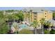 Resort exterior showing palm trees, swimming pool with lounge chairs and tables with umbrellas at 3000 Maingate Ln # 520, Kissimmee, FL 34747