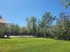 Spacious backyard featuring a black metal fence surrounding the pool, mature trees, and lush green grass at 3150 Appaloosa Ct, Kissimmee, FL 34746
