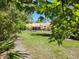 View of the expansive backyard with a screened-in pool area surrounded by mature trees, offering privacy and tranquility at 3150 Appaloosa Ct, Kissimmee, FL 34746