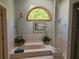 Bathroom with a soaking tub, plants, and a large window at 3150 Appaloosa Ct, Kissimmee, FL 34746