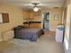 Cozy suite featuring a bed, kitchenette, and adjacent bathroom, illuminated by a ceiling fan with carpeting at 3150 Appaloosa Ct, Kissimmee, FL 34746