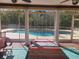 Inviting sunroom with view of pool, featuring tile flooring, ceiling fans, and access to the lush backyard at 3150 Appaloosa Ct, Kissimmee, FL 34746