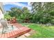 Inviting backyard with a wood deck, a pergola and a fire pit surrounded by lush greenery creating a private outdoor space at 322 N Rhodes St, Mount Dora, FL 32757