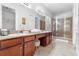 Bathroom featuring double sinks, granite countertops, walk-in shower, and tile flooring at 322 N Rhodes St, Mount Dora, FL 32757