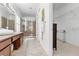 Bathroom featuring double sinks, granite countertops, walk-in shower, and tile flooring at 322 N Rhodes St, Mount Dora, FL 32757