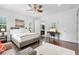 Bright bedroom featuring a ceiling fan, windows with shutters, and hardwood floors at 322 N Rhodes St, Mount Dora, FL 32757