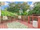 Outdoor deck with a table, chairs, and view of the wooded backyard at 322 N Rhodes St, Mount Dora, FL 32757