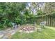 A backyard fire pit with a stone surround is accented by Adirondack-style chairs and benches, offering a cozy outdoor gathering space at 322 N Rhodes St, Mount Dora, FL 32757