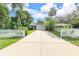 Charming single-story home with a manicured front yard, a long driveway, and a white picket fence at 322 N Rhodes St, Mount Dora, FL 32757