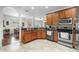 Well-equipped kitchen with stainless steel appliances, wooden cabinets, and a breakfast bar overlooking the living area at 322 N Rhodes St, Mount Dora, FL 32757