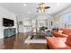 Open-concept living room with hardwood floors, ceiling fan, and natural light at 322 N Rhodes St, Mount Dora, FL 32757