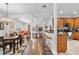 Open-concept living space with a dining area and kitchen featuring wood cabinetry and modern appliances at 322 N Rhodes St, Mount Dora, FL 32757