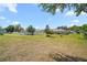 Large backyard with trees and neighboring homes at 328 Woodland Trl, Lady Lake, FL 32159