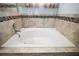 Bathroom bathtub featuring tiled surround with decorative accent at 328 Woodland Trl, Lady Lake, FL 32159
