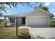 Charming single-story home with a two-car garage, manicured lawn, and inviting curb appeal at 328 Woodland Trl, Lady Lake, FL 32159