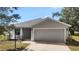 Exterior of home with garage and landscaping at 328 Woodland Trl, Lady Lake, FL 32159