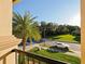 Balcony view showcases a palm tree, lush lawn, and neighborhood street with parked car under clear skies at 3687 Farm Bell Pl, Lake Mary, FL 32746