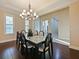 Dining room with chandelier, tray ceiling, dark wood floors and bright natural light at 3687 Farm Bell Pl, Lake Mary, FL 32746