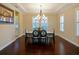 Formal dining room with chandelier, tray ceiling, dark hardwood floors and natural light from the windows at 3687 Farm Bell Pl, Lake Mary, FL 32746
