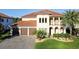Stunning two-story home with a red tile roof, lush landscaping, and a paver driveway at 3687 Farm Bell Pl, Lake Mary, FL 32746