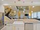Open kitchen with stone countertops, stainless steel appliances, farmhouse sink and view of the staircase and living room at 3687 Farm Bell Pl, Lake Mary, FL 32746