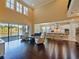 Spacious living room with high ceilings, water view through sliding glass doors, and open to the kitchen and dining area at 3687 Farm Bell Pl, Lake Mary, FL 32746