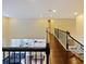 A loft features dark wood floors, black iron railings, and a view of the kitchen and dining area below at 3687 Farm Bell Pl, Lake Mary, FL 32746