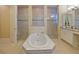 Luxury bathroom featuring a soaking tub, separate glass-enclosed showers, and dual vanities at 3687 Farm Bell Pl, Lake Mary, FL 32746