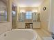 Relaxing main bathroom with soaking tub, glass shower, dual sinks, and bright lighting at 3687 Farm Bell Pl, Lake Mary, FL 32746