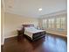 Serene main bedroom with hardwood floors, tray ceiling, and large windows with plantation shutters at 3687 Farm Bell Pl, Lake Mary, FL 32746