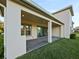 Covered patio with sleek sliding glass doors opens to the home's interior, framed by a neat green lawn at 3687 Farm Bell Pl, Lake Mary, FL 32746