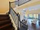 A home staircase is accented by dark wood and detailed black iron with a view of the living room at 3687 Farm Bell Pl, Lake Mary, FL 32746